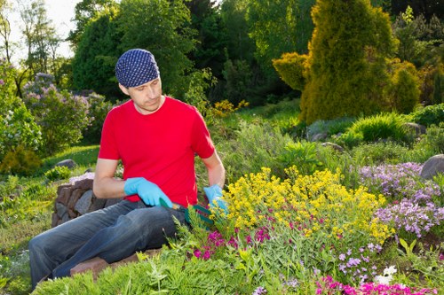 Worker using a strimmer with protective gear in a public park